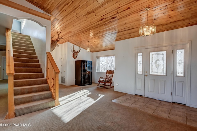 carpeted entryway featuring wood ceiling, vaulted ceiling, and an inviting chandelier