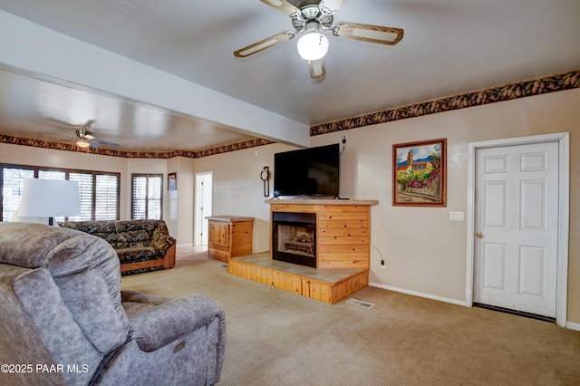 carpeted living room with ceiling fan and a fireplace