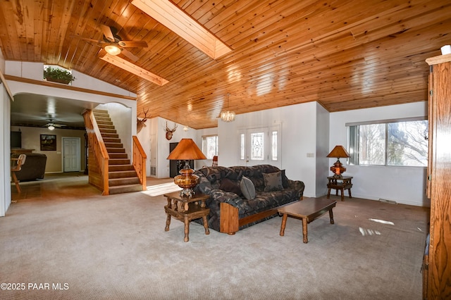 carpeted living room featuring a skylight, plenty of natural light, high vaulted ceiling, and wooden ceiling