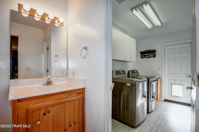 washroom featuring cabinets, independent washer and dryer, and sink