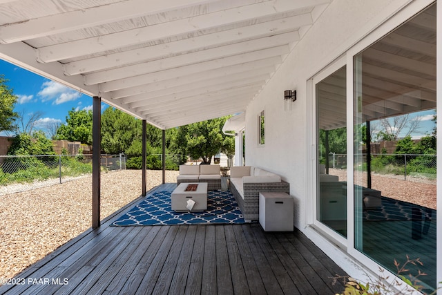 wooden terrace featuring an outdoor living space with a fire pit