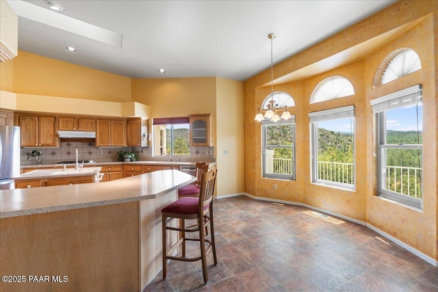 1330 Solar Heights Dr, Prescott, AZ 86303 - kitchen featuring under cabinet range hood, baseboards, freestanding refrigerator, healthy amount of natural light, and recessed lighting