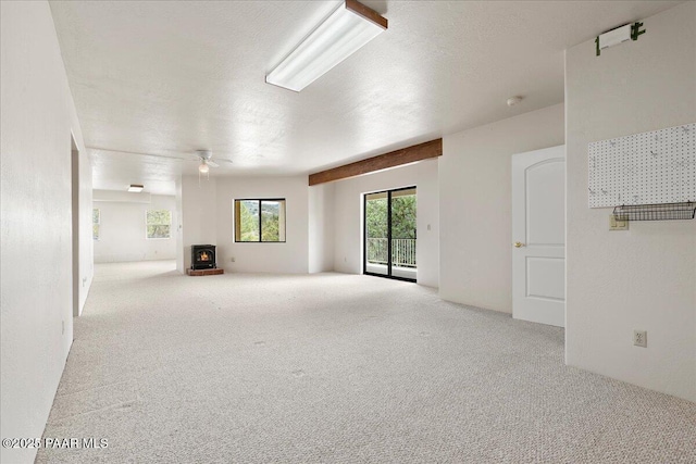 1330 Solar Heights Dr, Prescott, AZ 86303 - unfurnished living room featuring carpet flooring, a wood stove, a textured ceiling, and ceiling fan