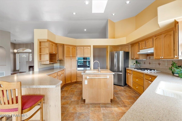 1330 Solar Heights Dr, Prescott, AZ 86303 - kitchen with stainless steel appliances, under cabinet range hood, open shelves, an island with sink, and backsplash