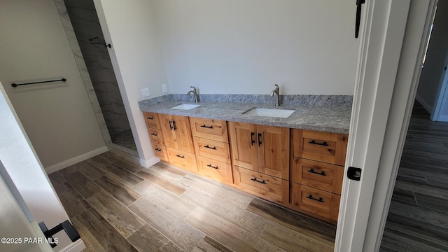 12880 E Brody Trl, Dewey-Humboldt, AZ 86327 - bathroom with tiled shower, wood finished floors, double vanity, and baseboards