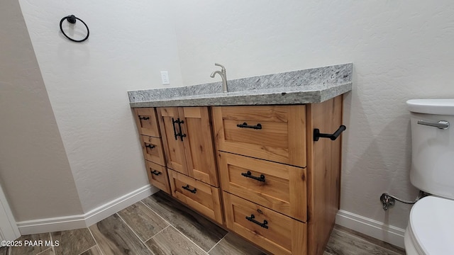 12880 E Brody Trl, Dewey-Humboldt, AZ 86327 - half bathroom featuring toilet, wood finished floors, vanity, and baseboards