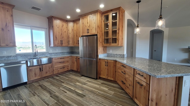 12880 E Brody Trl, Dewey-Humboldt, AZ 86327 - kitchen with stainless steel appliances, a sink, arched walkways, a peninsula, and glass insert cabinets