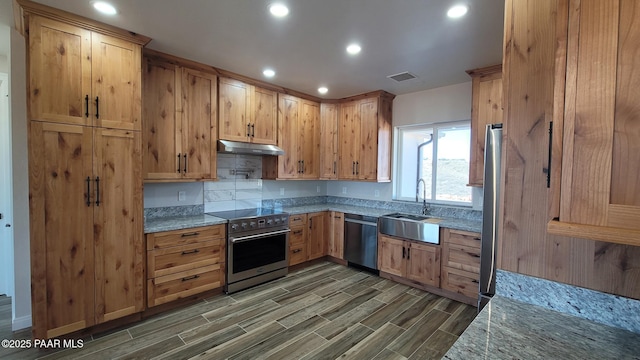 12880 E Brody Trl, Dewey-Humboldt, AZ 86327 - kitchen with appliances with stainless steel finishes, a sink, under cabinet range hood, dark wood-style flooring, and light stone countertops