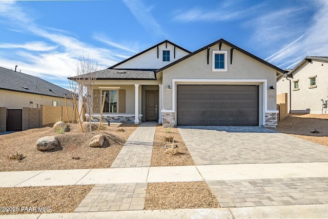 view of front facade with an attached garage, fence, decorative driveway, a porch, and stucco siding