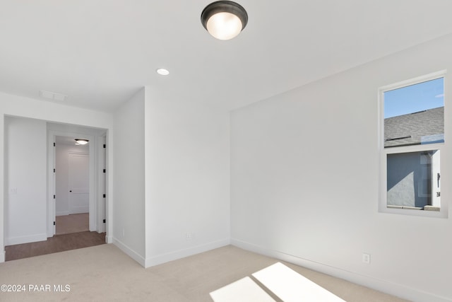 unfurnished room featuring light colored carpet