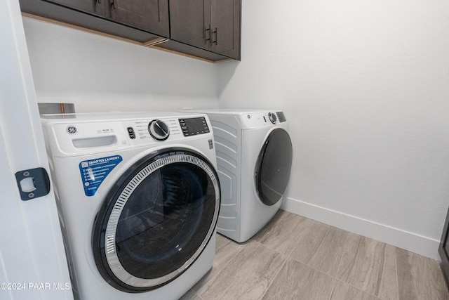 laundry room featuring washing machine and dryer and cabinets