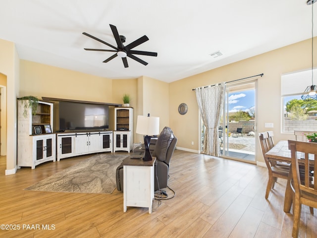 living room featuring ceiling fan, baseboards, wood finished floors, and visible vents