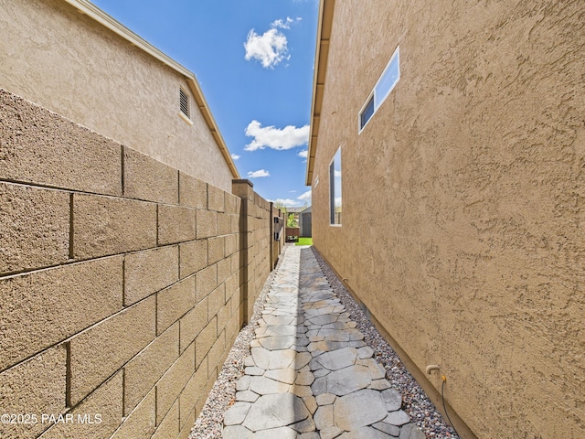 view of home's exterior with fence and stucco siding