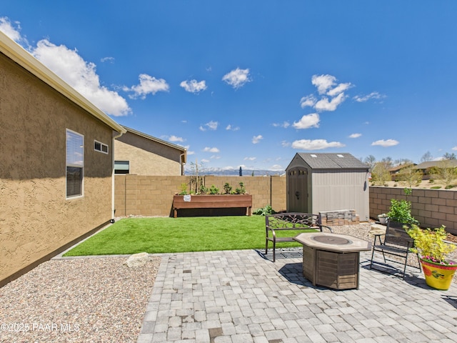 view of patio / terrace featuring a fenced backyard, an outdoor structure, a fire pit, and a storage shed