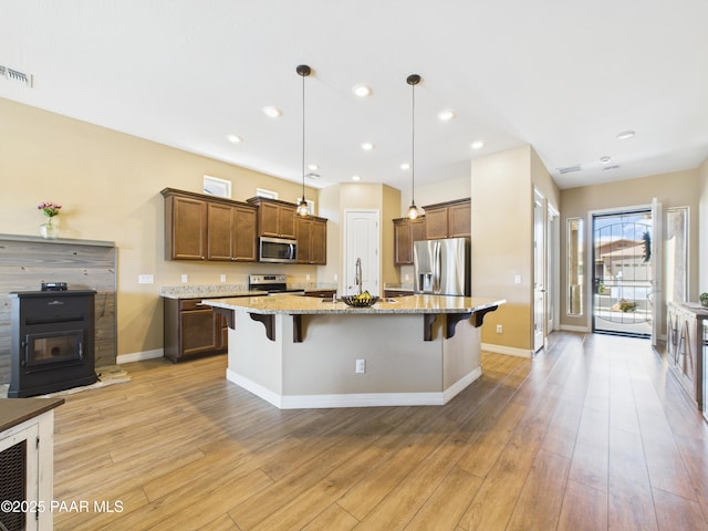 kitchen with baseboards, a kitchen breakfast bar, visible vents, and appliances with stainless steel finishes