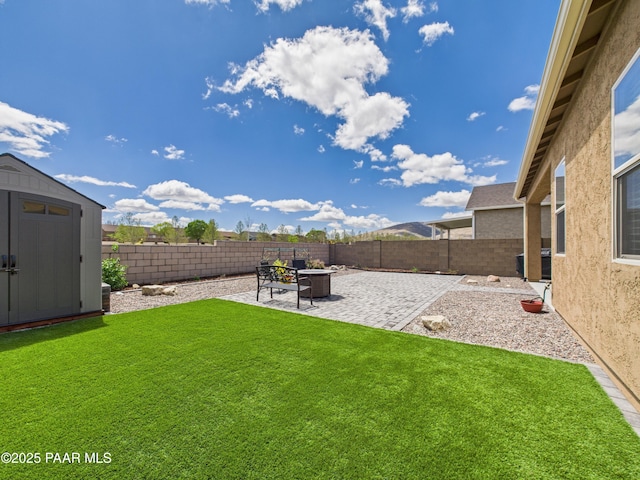 view of yard featuring an outdoor structure, a patio area, a shed, and a fenced backyard