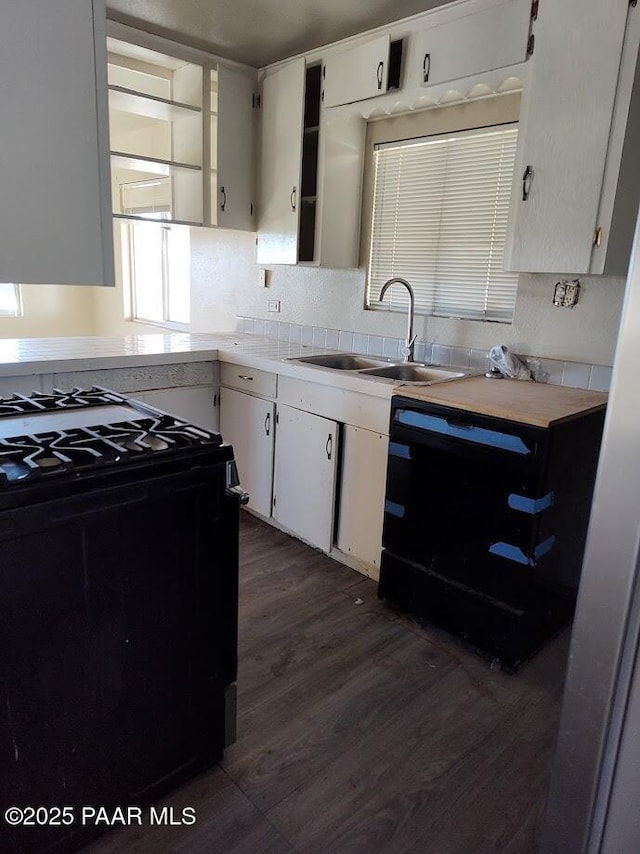 kitchen featuring sink, white cabinets, black appliances, and dark hardwood / wood-style flooring