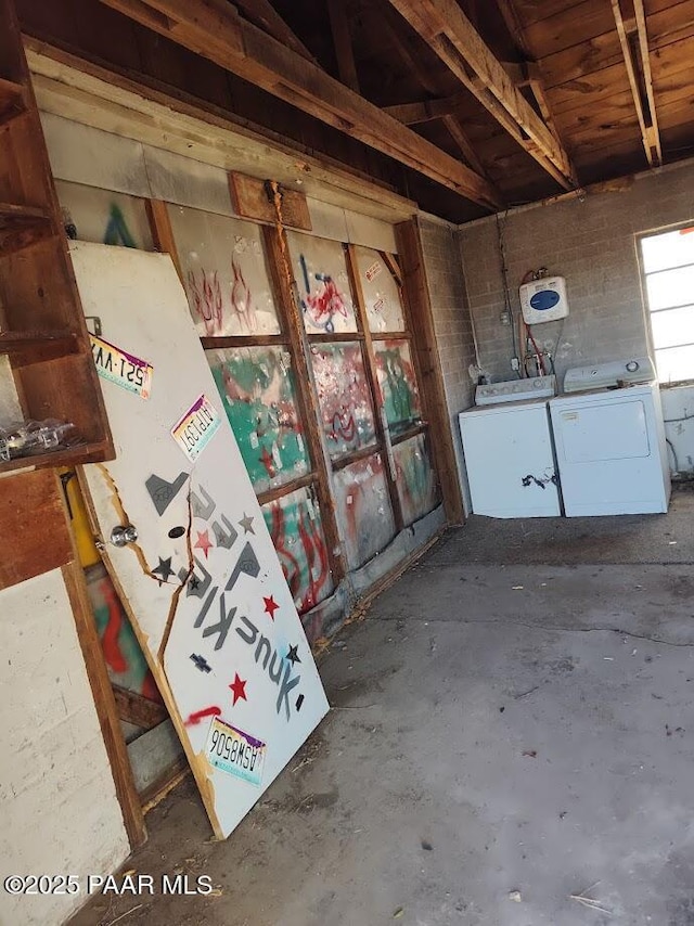 misc room featuring wooden ceiling, concrete flooring, and washer and clothes dryer