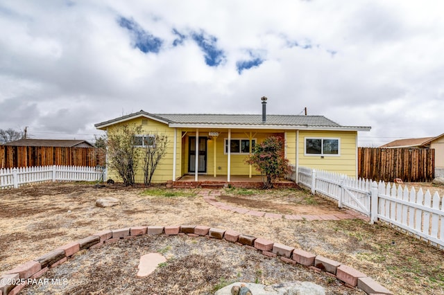 back of house with a fenced backyard and a gate