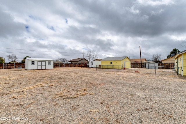 view of yard with an outbuilding, a fenced backyard, and a shed