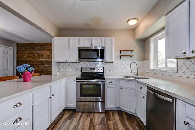 kitchen featuring a sink, appliances with stainless steel finishes, light countertops, and white cabinetry