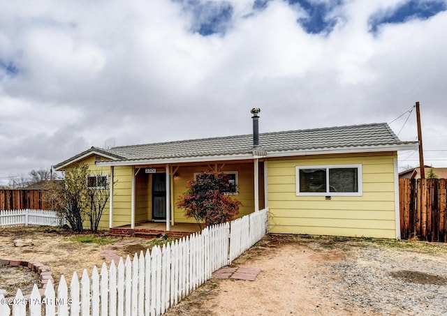 view of front of property with a tiled roof, a porch, and fence