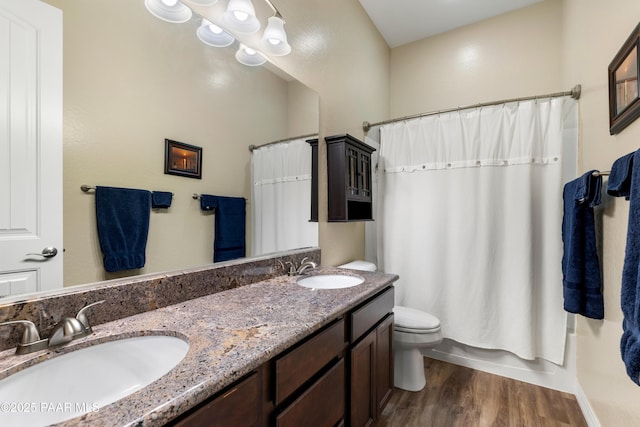 full bathroom with toilet, shower / tub combo with curtain, vanity, and hardwood / wood-style flooring