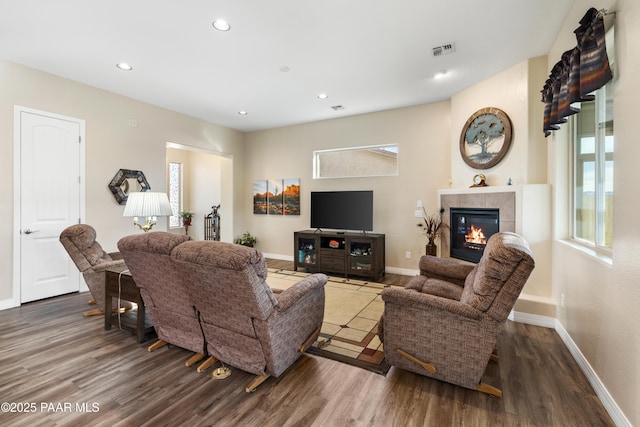 living room with dark hardwood / wood-style floors and a tiled fireplace