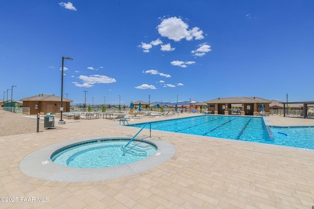 view of swimming pool featuring a patio and a hot tub