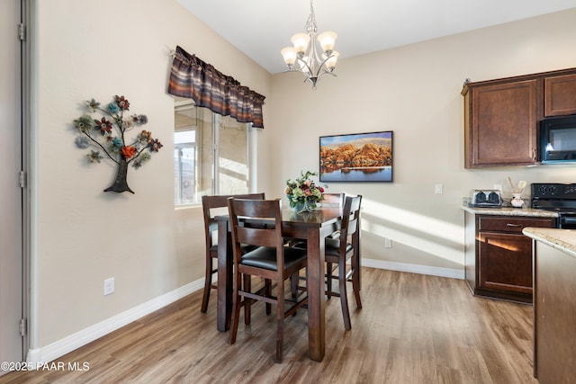 dining space featuring light hardwood / wood-style flooring and a notable chandelier