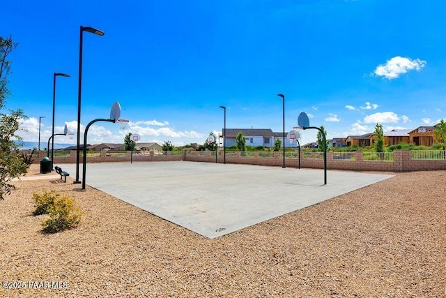 view of sport court with community basketball court, fence, and a residential view