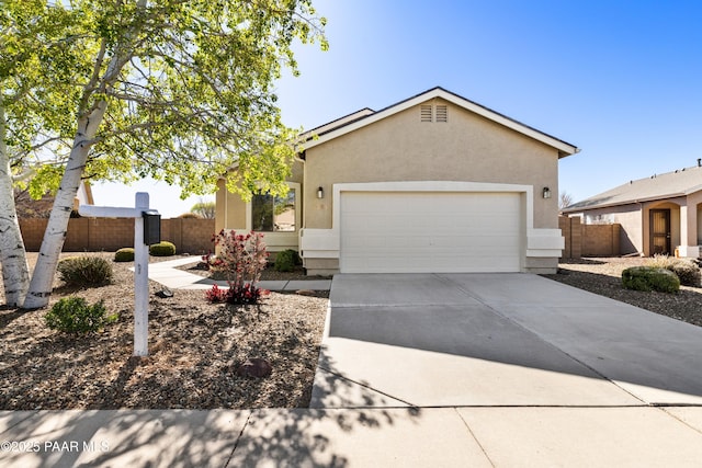 single story home with stucco siding, an attached garage, fence, and concrete driveway