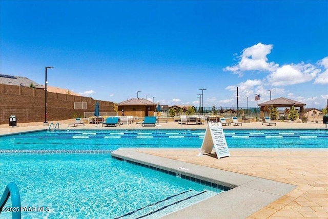 community pool featuring fence and a patio