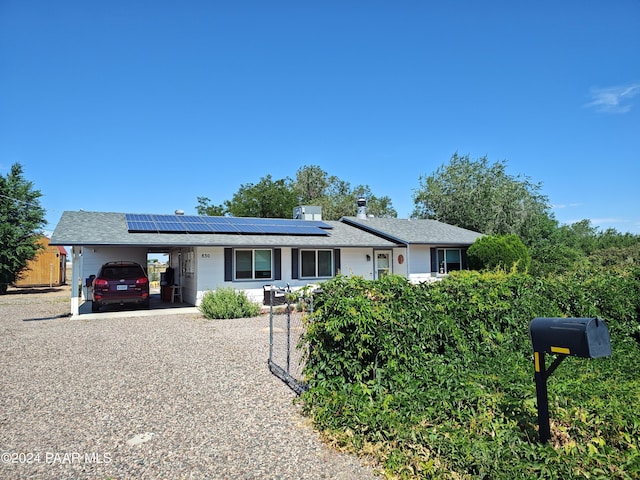 ranch-style house featuring solar panels and a garage