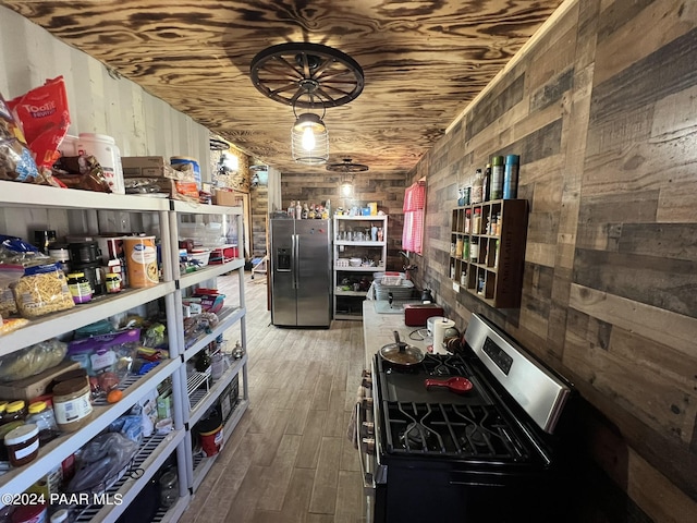 47 N Humble Ln, Ash Fork, AZ 86320 - kitchen with appliances with stainless steel finishes, wood walls, wood finished floors, and open shelves