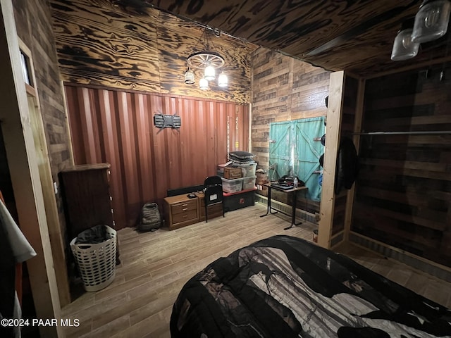 bedroom featuring wood walls and wood-type flooring