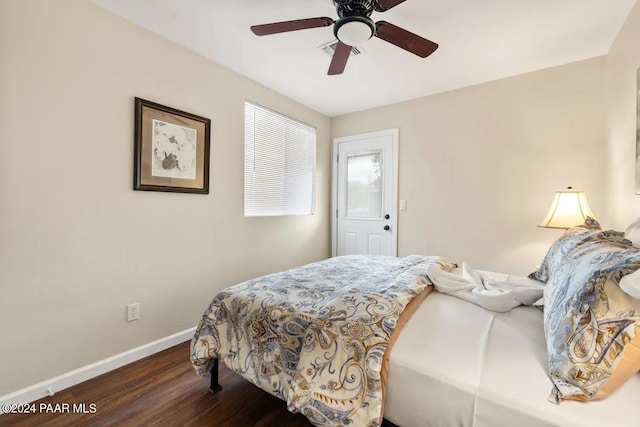 bedroom with a ceiling fan, visible vents, wood finished floors, and baseboards