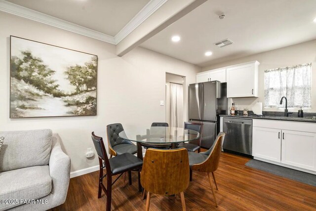 living area with baseboards, ornamental molding, recessed lighting, wood finished floors, and a glass covered fireplace