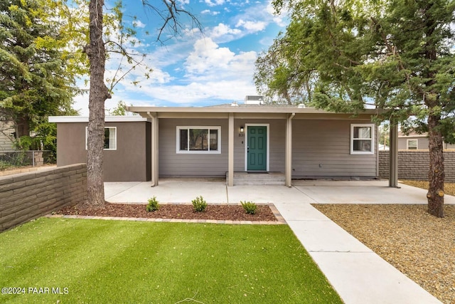 ranch-style home featuring a front lawn and fence