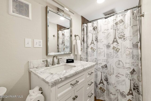 full bathroom featuring vanity, a shower with curtain, and visible vents