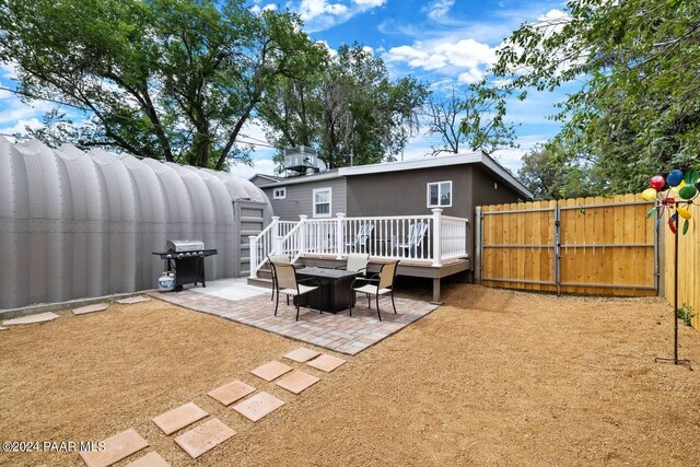 rear view of house featuring stucco siding, a patio, fence, and a gate