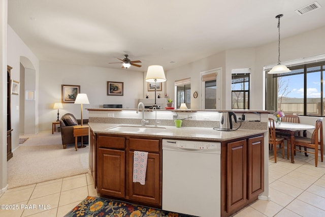 kitchen with visible vents, a kitchen island with sink, white dishwasher, a sink, and open floor plan