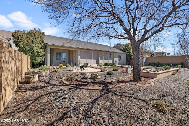 rear view of house featuring a patio, a garden, a fenced backyard, and stucco siding