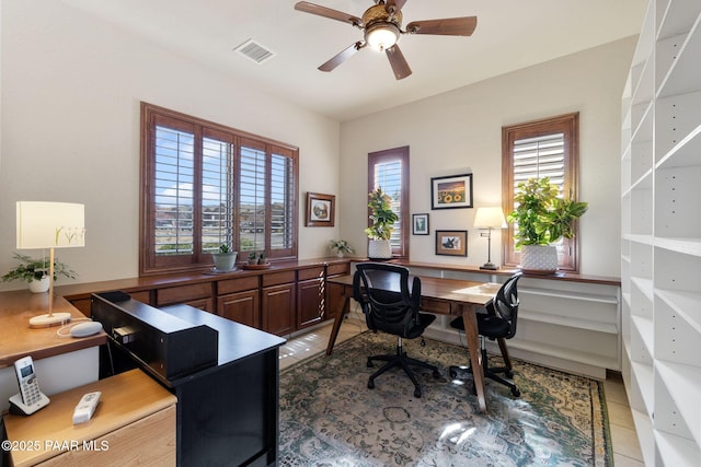 office with tile patterned floors, visible vents, and ceiling fan