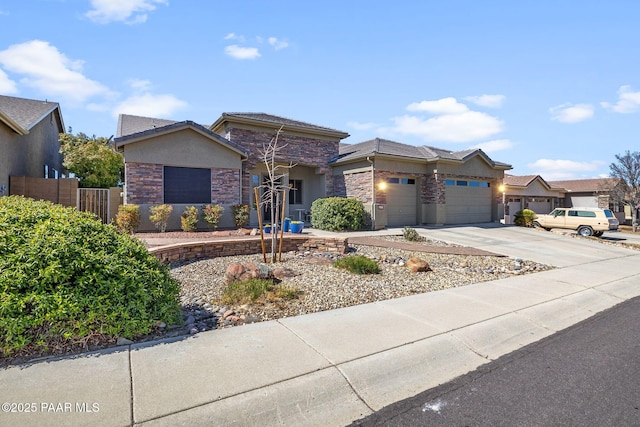 view of front of property featuring fence, an attached garage, stucco siding, concrete driveway, and stone siding