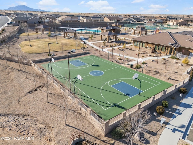 view of basketball court featuring community basketball court, fence, and a residential view