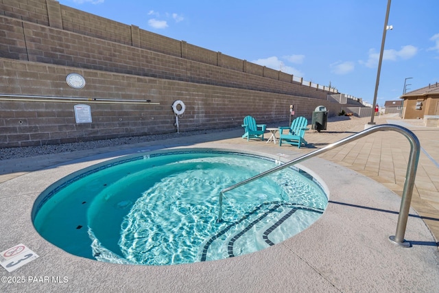 view of swimming pool featuring a community hot tub, a patio, and fence