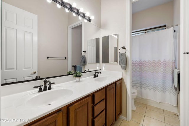 full bathroom with tile patterned floors, double vanity, toilet, and a sink