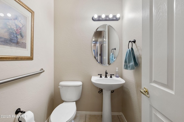 bathroom featuring tile patterned floors, toilet, and baseboards