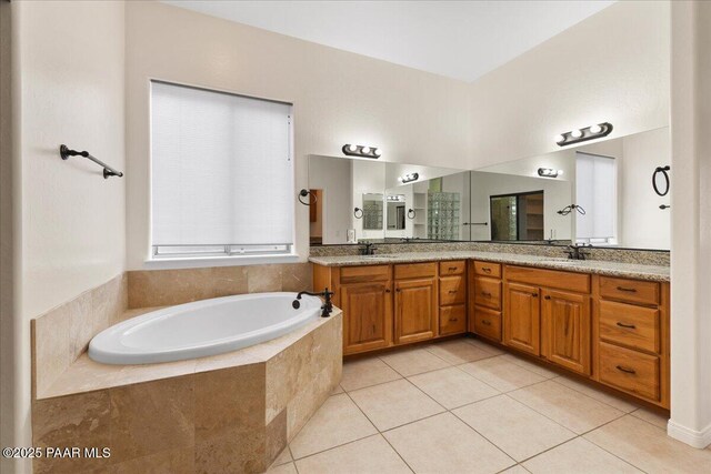 bathroom with a sink, a garden tub, double vanity, and tile patterned flooring